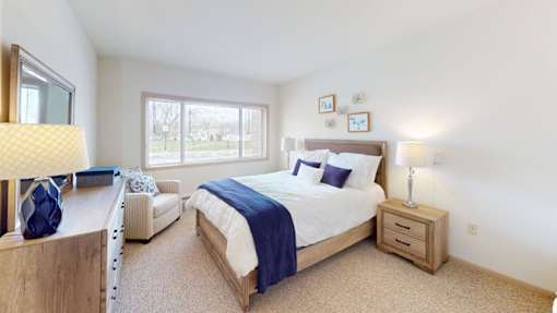 A bedroom with a large bed and a window.