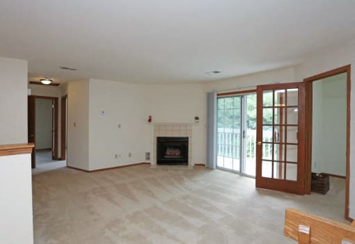 A living room with a fireplace and sliding glass doors.