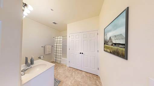 A bathroom with a white sink and a white door.