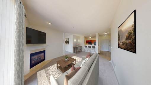 A living room with a grey couch and a flat screen TV mounted on the wall.