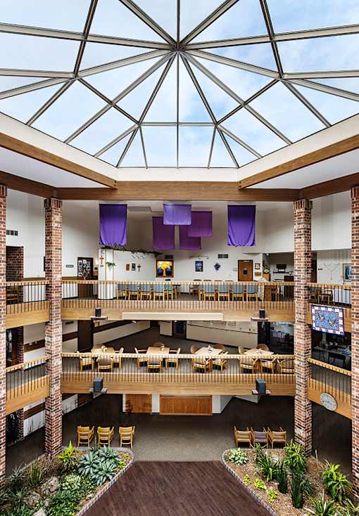 a view of therium of a building with tables and chairs