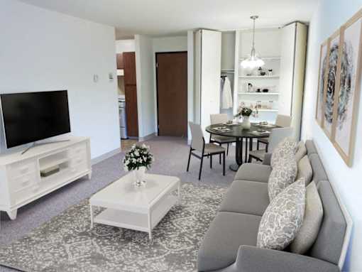 a living room and dining room with a couch and a television