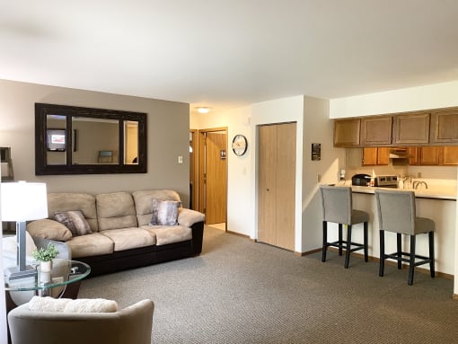 a living room with a couch and a kitchen with a table and chairs