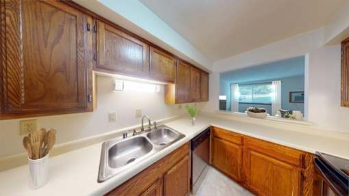 A kitchen with wooden cabinets and a stainless steel sink.