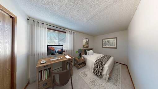 A bedroom with a bed, desk, and chair.