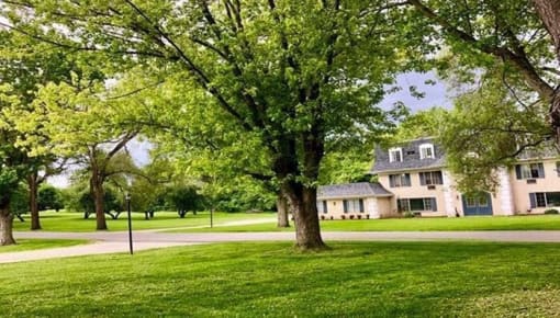 a house on the side of a field with trees