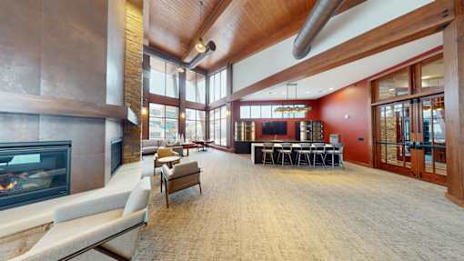 A large room with a fireplace and a long table.