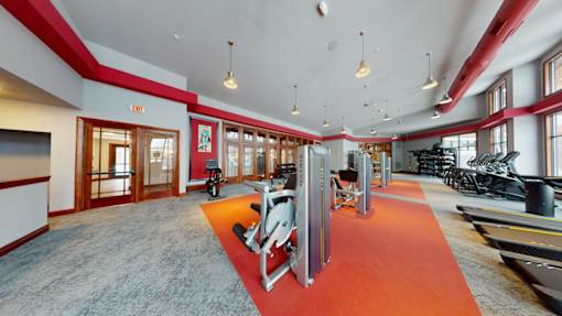 A gym with a red carpet and various exercise equipment.