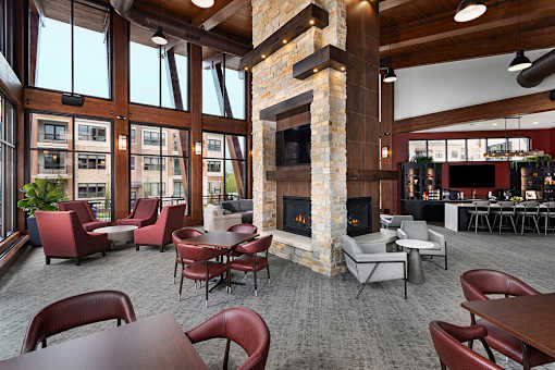 A large room with a fireplace and chairs.