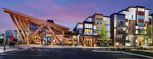 A large wooden structure is in front of a multi-story building.