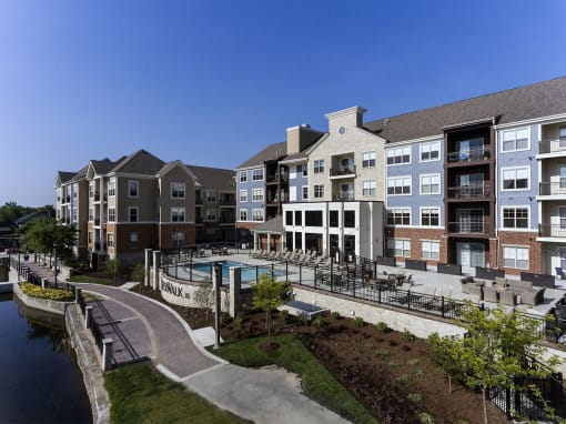 an exterior view of an apartment building with a swimming pool