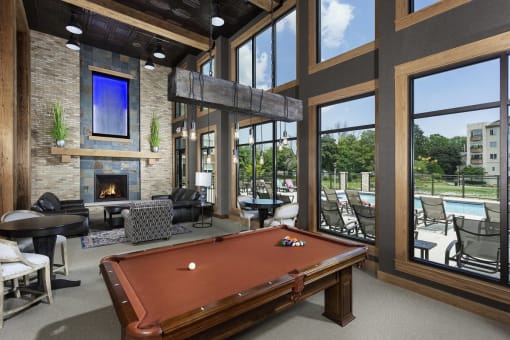 a clubhouse with a pool table and a fireplace
