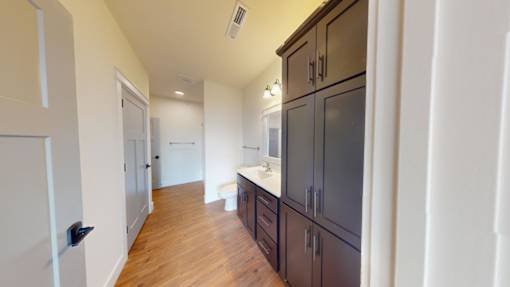A kitchen with dark brown cabinets and a white fridge.