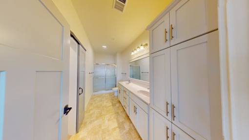 A white kitchen with a sink and cabinets.