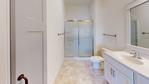 A bathroom with a toilet, sink, and shower.