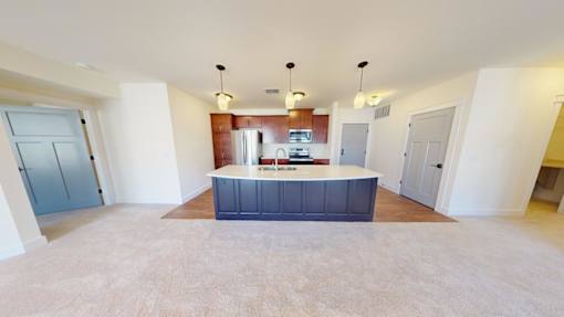 A kitchen area with a blue island in the middle of a room with white walls.