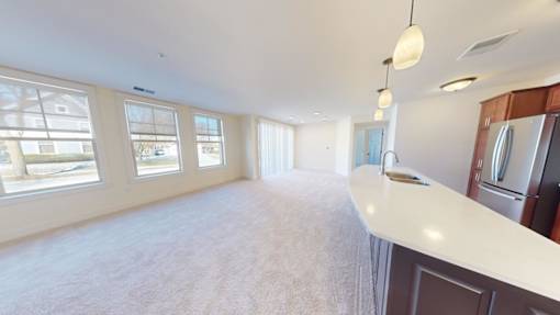 A spacious kitchen with a refrigerator, cabinets, and a countertop.