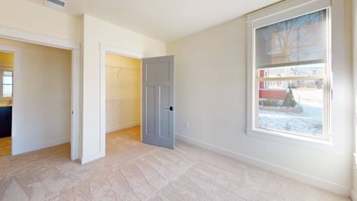 A room with a grey door and a window showing a snowy landscape outside.