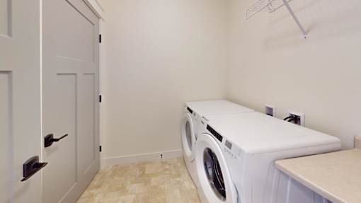 A white washing machine in a laundry room.