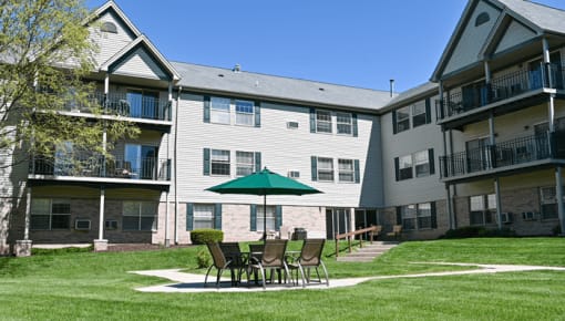 a patio with an umbrella in front of an apartment building
