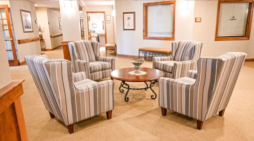 a living room with striped chairs and a table
