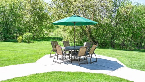 a patio with a table and chairs and an umbrella