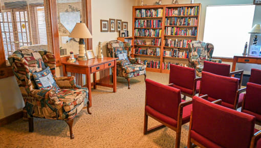 a living room filled with chairs and a table with books