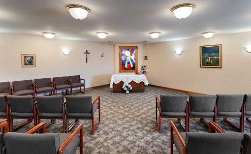 a conference room with chairs and a table with a cross on the wall