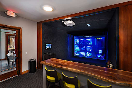 A room with a bar and a screen on the wall.