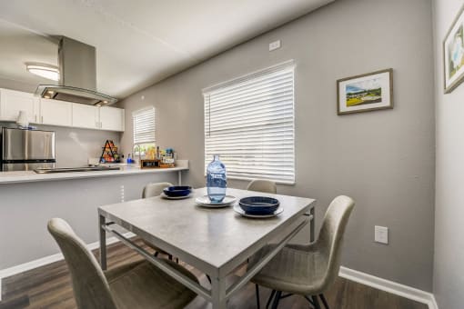 a dining area with a table and chairs and a kitchen