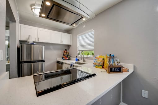 the kitchen is equipped with stainless steel appliances and white countertops