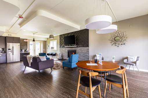 A modern living room with a fireplace and a dining table set for four.