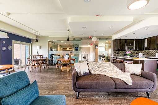 A living room with a grey couch and a dining table.