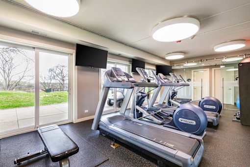 A gym with treadmills and a television.