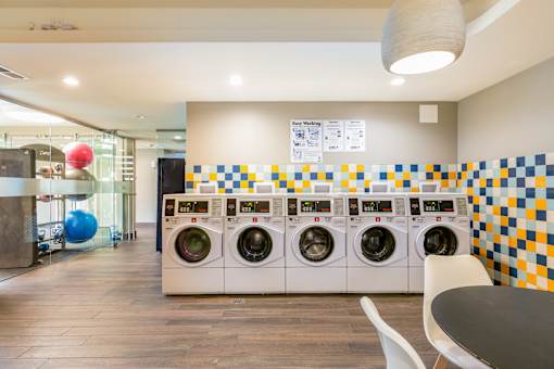 A laundromat with a row of washers and dryers.