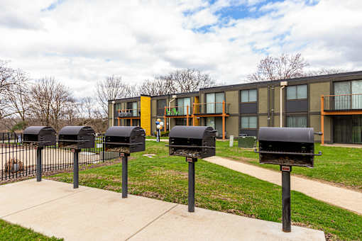A row of black mailboxes in front of a building.