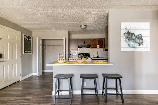 A kitchen with a bar stool in front of a counter.