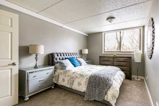 A bedroom with a bed, nightstand, and lamp.