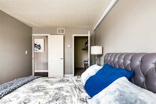 A bedroom with a large bed and a lamp.