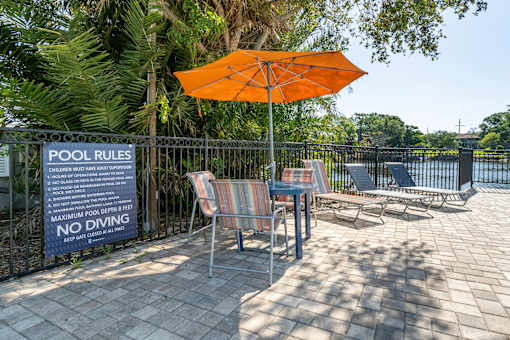 A pool area with a sign that states "POOL RULES" and "NO DIVING".