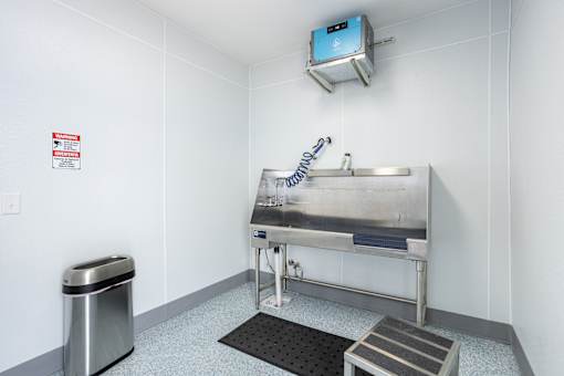 A bathroom with a sink and a trash can.
