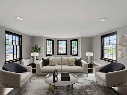 A modern living room with a large sofa, two chairs, and a coffee table.