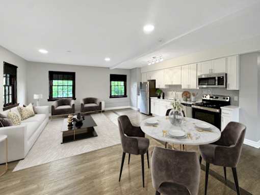 A modern living room with a dining area and kitchen in the background.