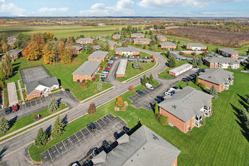 A large building complex with a parking lot in front. at CenterPointe Apartments & Townhomes, Canandaigua, NY