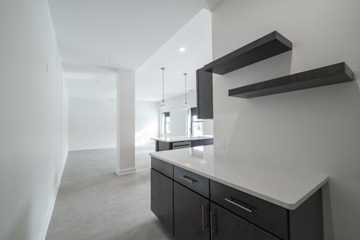 A kitchen with a white counter top and black cabinets.