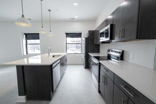 A modern kitchen with black cabinets and stainless steel appliances.