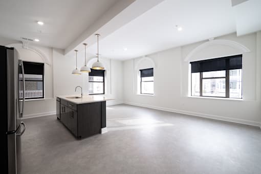 A spacious kitchen with a sink, refrigerator, and a window.