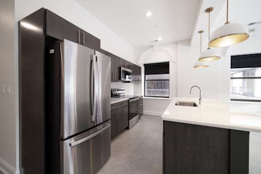A modern kitchen with a stainless steel refrigerator and a white countertop.