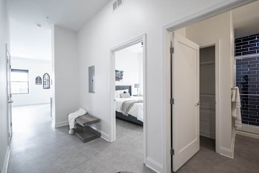 A bedroom with a bed and a bench in the corner.