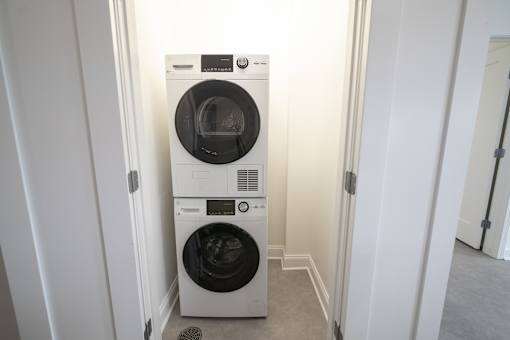 A white front load washing machine in a small laundry room.